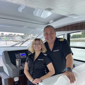 Smiling captain and female crew member aboard LivBlue’s luxury charter boat in Naples, Florida, ready to guide your custom boat tour or yacht charter.