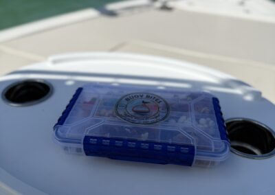 Buoy Bites snack tackle box on a white table at the bow of a boat with the Gulf in the background