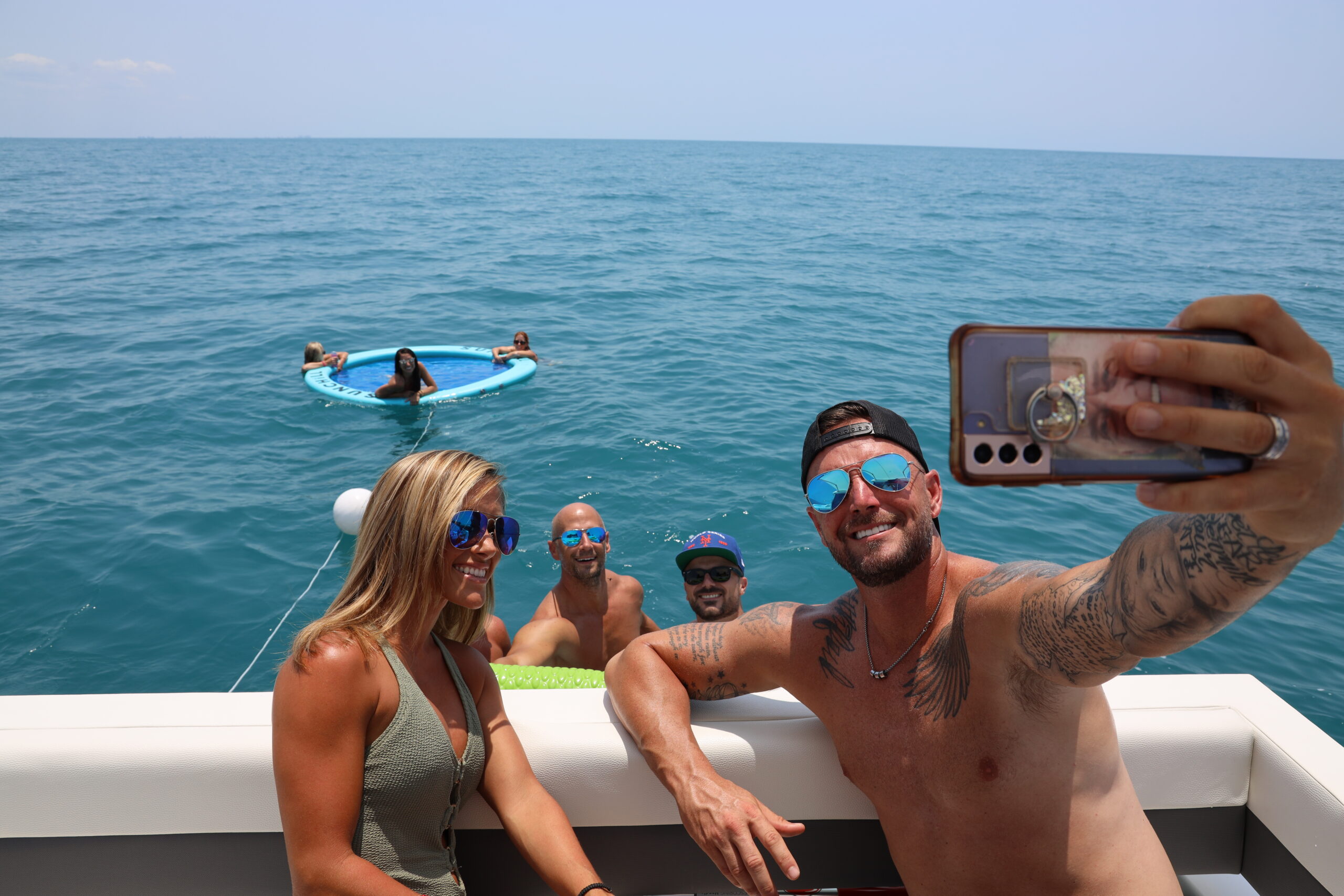 Guests floating and smiling during a LivBlue charter in Naples, Florida aboard BRADventures. Premium on-the-water experience with floats and full service.