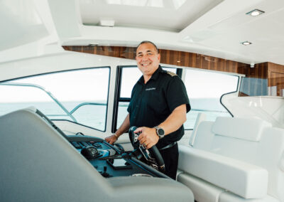 Captain Bill smiling at the helm in Naples, FL
