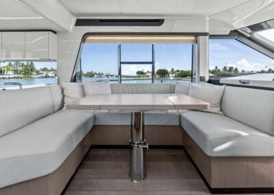 Spacious salon with panoramic windows, plush lounge seating, modern galley, and helm station aboard Tailgate Time